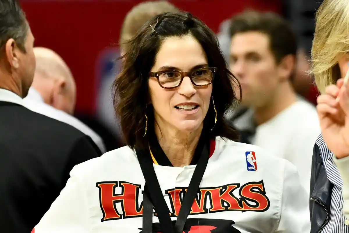 Jami Gertz, najbogatija glumica, stoji ispred logotipa NBA tima Atlanta Hawks, simbolizirajući spoj njezine glumačke i poslovne karijere.